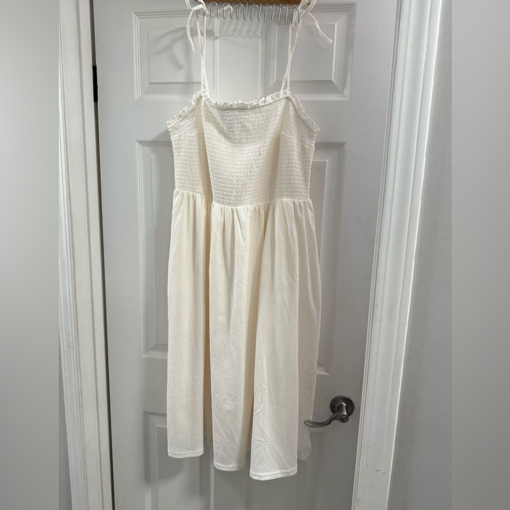 Women’s off white, baby doll style dress with tie straps.